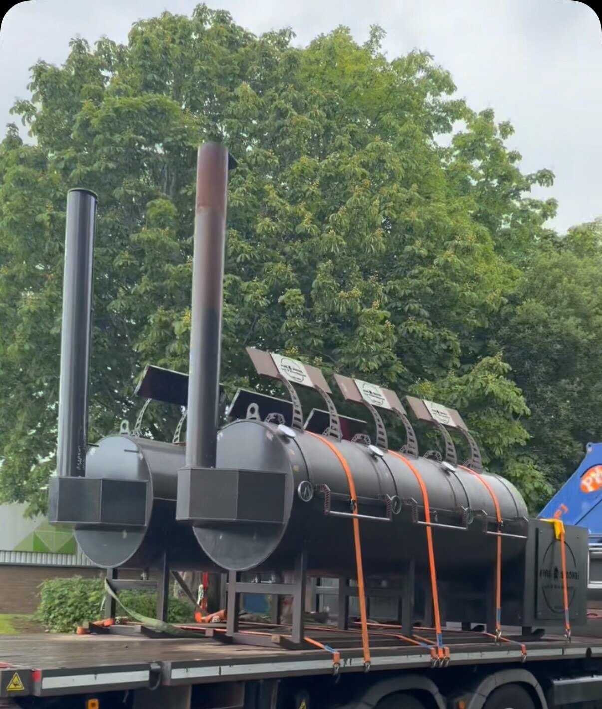 A new custom-built Fire & Smoke offset smoker strapped to a flatbed lorry on delivery day